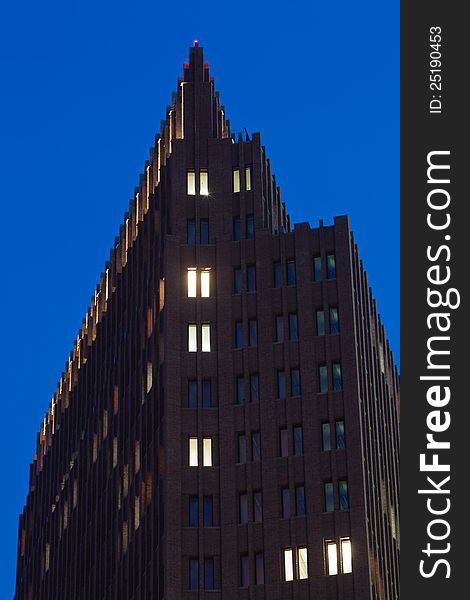 Tower building with lightened windows at blue night sky. Tower building with lightened windows at blue night sky