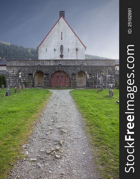 Picture of a graveyard buildning with a pathway leading to it. Picture of a graveyard buildning with a pathway leading to it