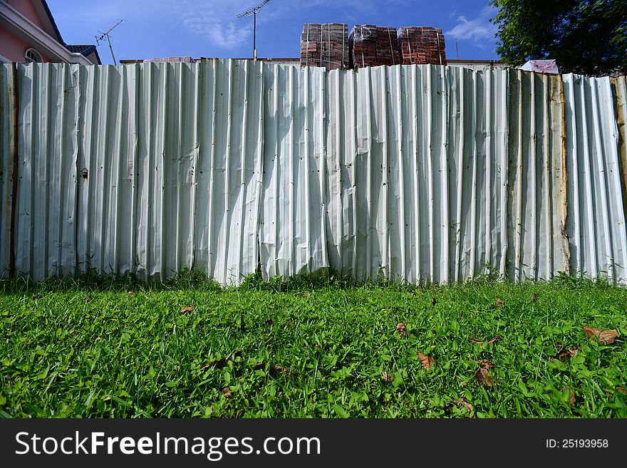 Picture of a fence separating two neighbors. Can be used as a background or to illustrate a division. Picture of a fence separating two neighbors. Can be used as a background or to illustrate a division.