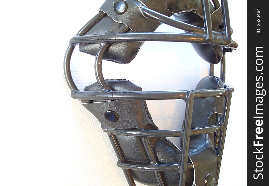 Black baseball catcher’s face mask on a white background with space for ad copy / text. Black baseball catcher’s face mask on a white background with space for ad copy / text.