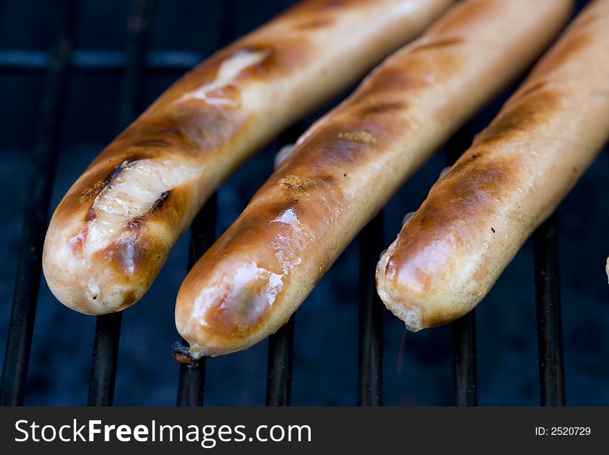 A summer bbq staple hotdogs on the grill close up shots shallow depth of view nice grill marks. A summer bbq staple hotdogs on the grill close up shots shallow depth of view nice grill marks