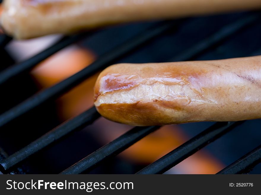 A summer bbq staple hotdogs on the grill close up shots shallow depth of view nice grill marks. A summer bbq staple hotdogs on the grill close up shots shallow depth of view nice grill marks