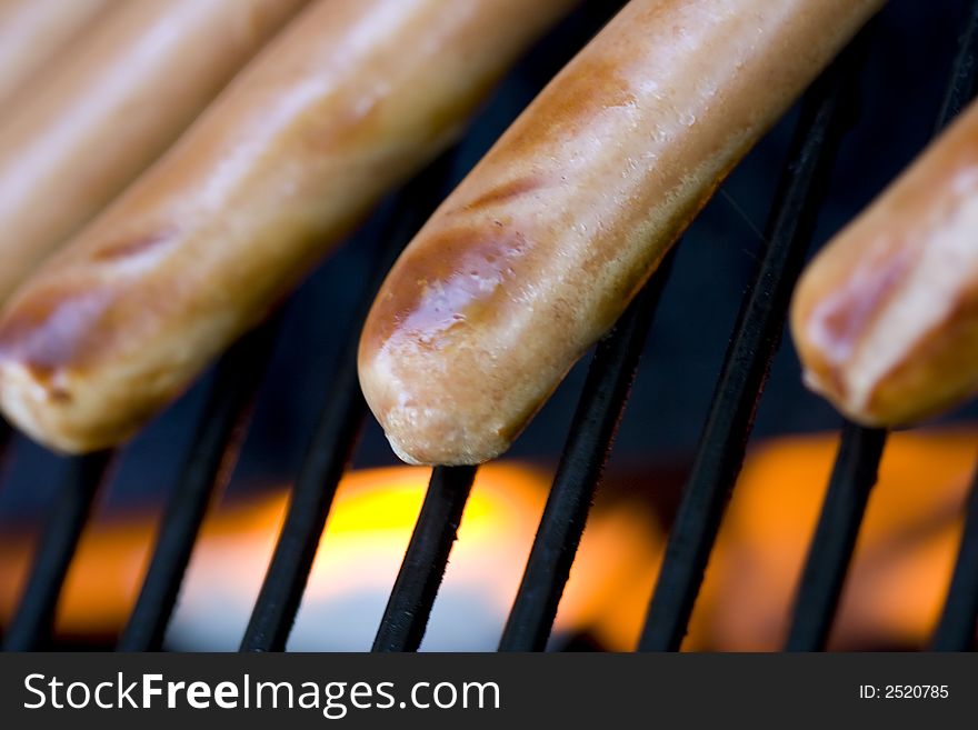 A summer bbq staple hotdogs on the grill close up shots shallow depth of view nice grill marks. A summer bbq staple hotdogs on the grill close up shots shallow depth of view nice grill marks