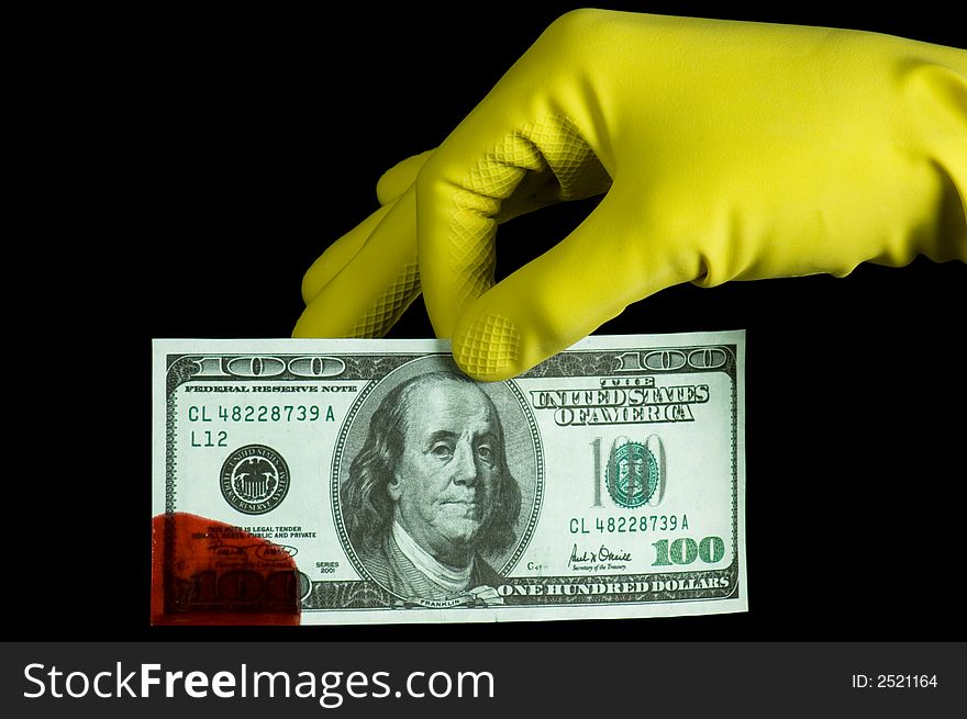 A hand in glove holding bloody dollar banknote