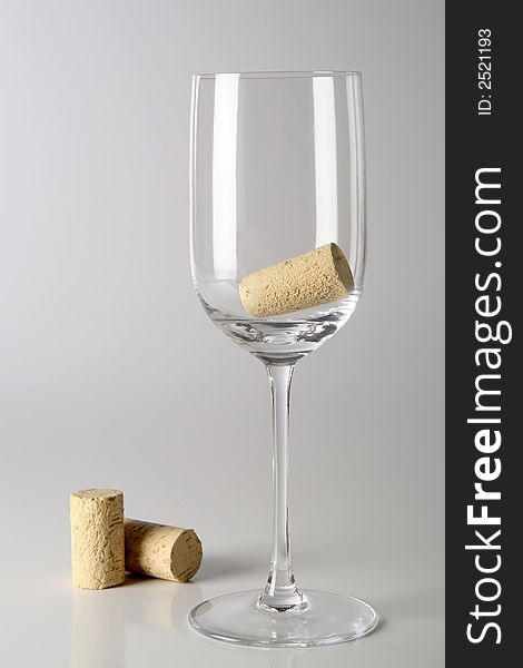 A glass with corks inside on a neutral background