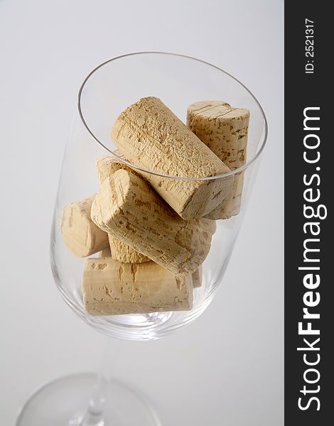 A glass with corks inside on a neutral background