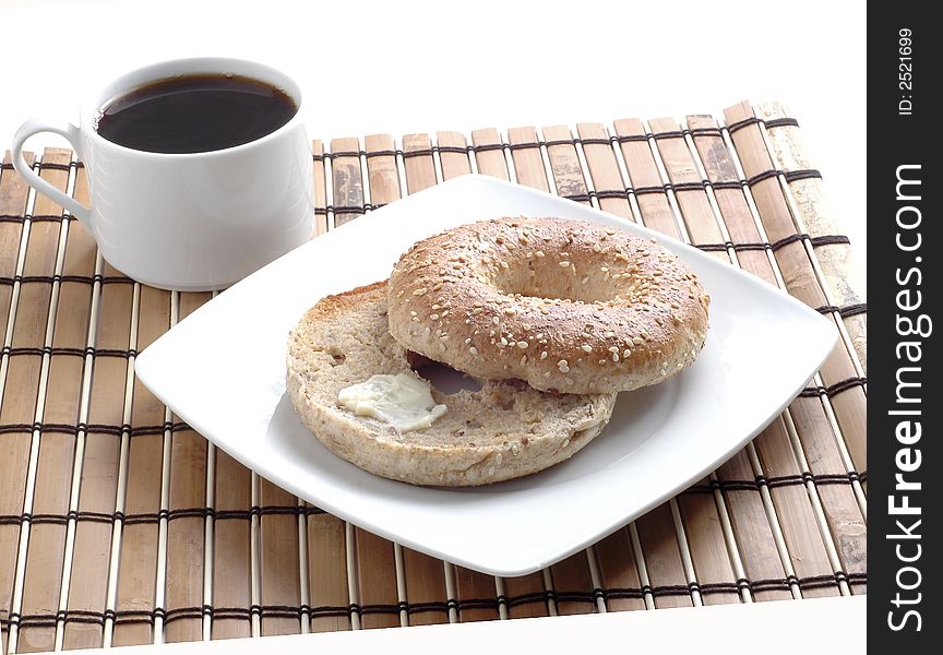 Toasted bagel with butter and a cup of black coffee. Toasted bagel with butter and a cup of black coffee.