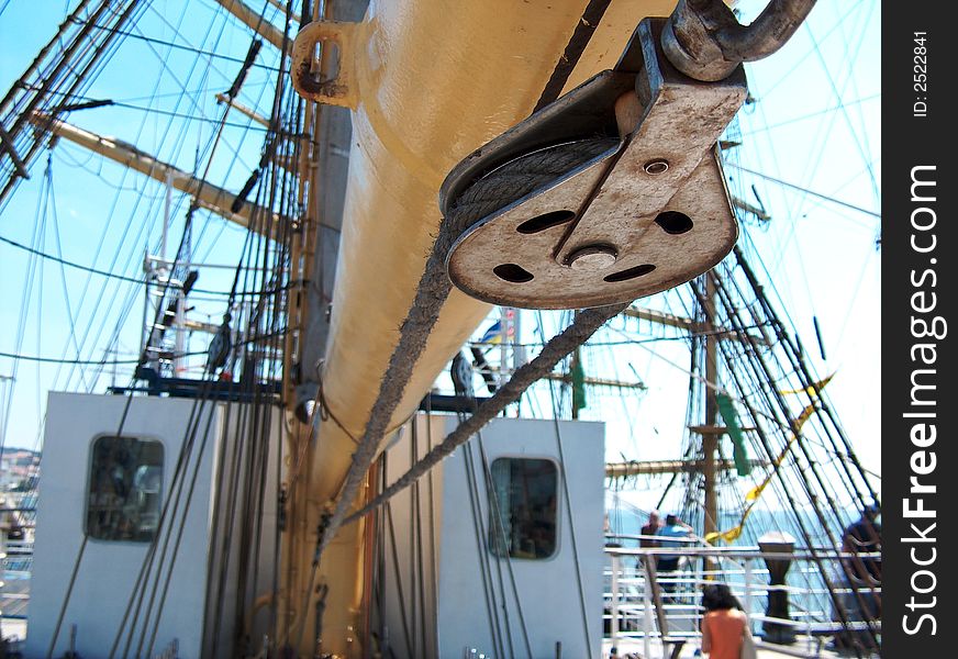 Close-up of a rusty metal pulley from a tall ship.