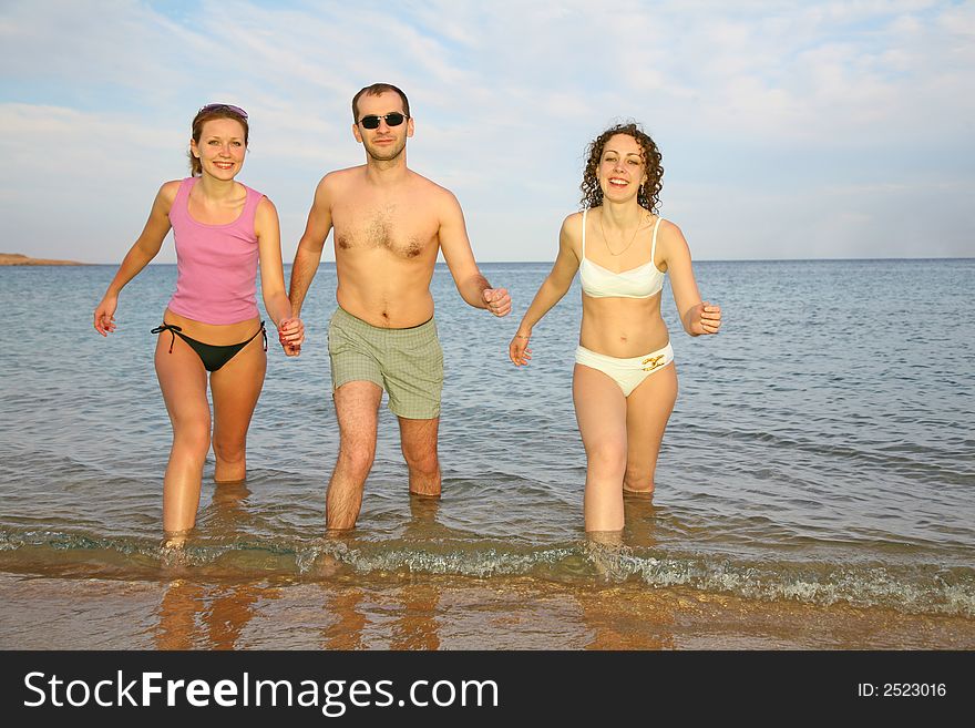 Man and two girls leave the sea