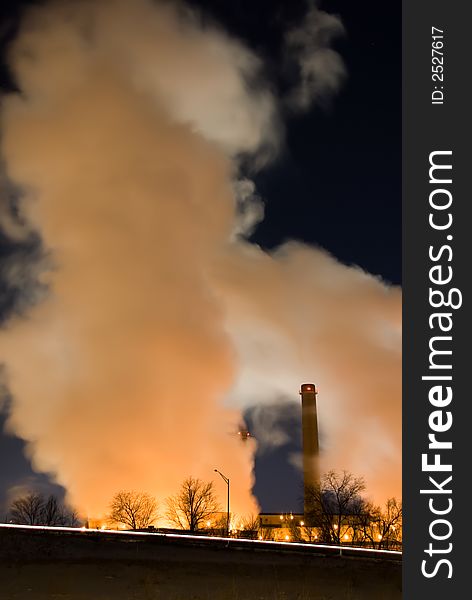 Vertical color image of steam clouds from coal fueled power plant. Vertical color image of steam clouds from coal fueled power plant