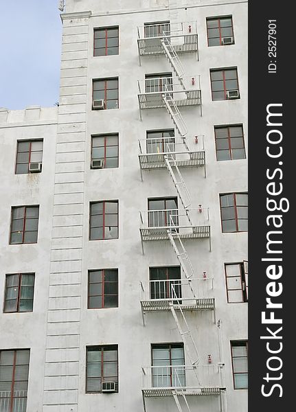 A white fire escape on the side of a white building