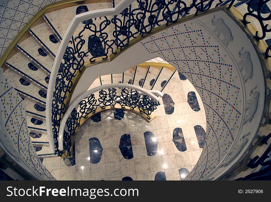 A white circular staircase descending into the distance