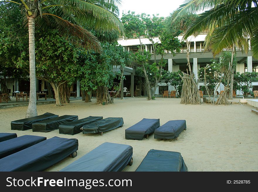Beach Beds on a sea sand , lined up to be taken  in front of hotel building