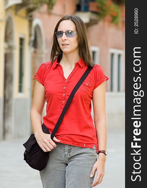 Woman wearing red top walking in a european street. Woman wearing red top walking in a european street