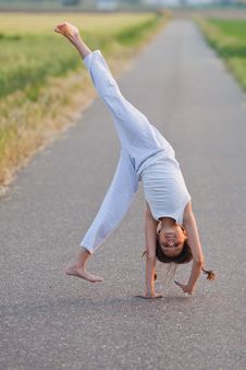 Young Girl Makes A Cartwheel Royalty Free Stock Photo