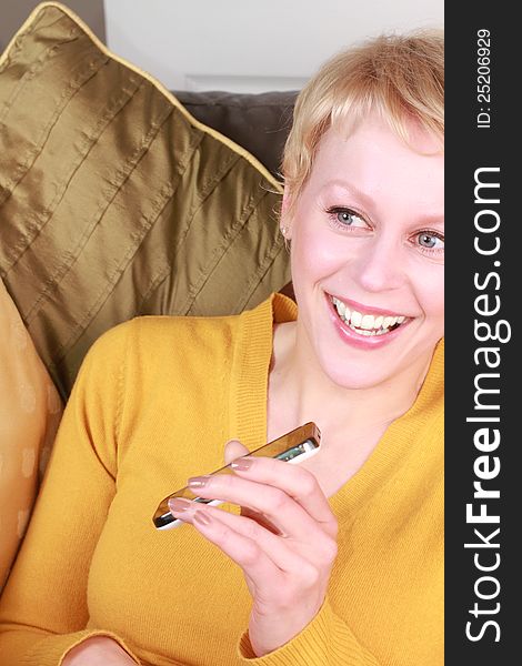 Image of a lady on her mobile phone laughing at home. Image of a lady on her mobile phone laughing at home