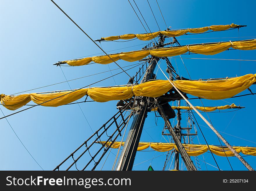 View of the yellow, unfurled sails of a ship. View of the yellow, unfurled sails of a ship
