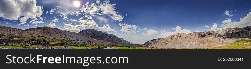 The scenery of China& x27 s Tibet Plateau under the sun, blue sky and white clouds, the Qinghai-Tibet landscape consisting of fields, roads and mountains.