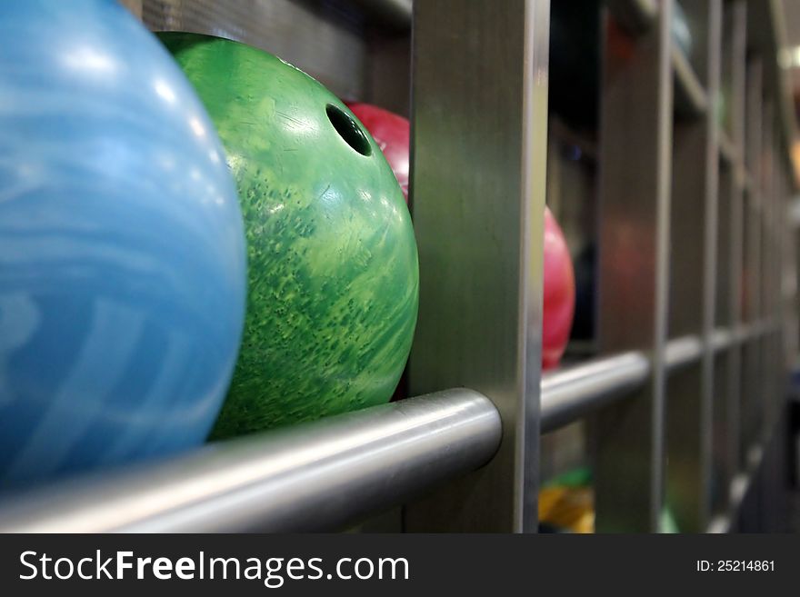 Bowling balls, yellow, blue, pink.rack for bowling balls
