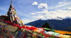 Looking At The Meili Snow Mountain In The Distance Through The Prayer Flags Fluttering In The Wind. Yun Nan China. Royalty Free Stock Photography