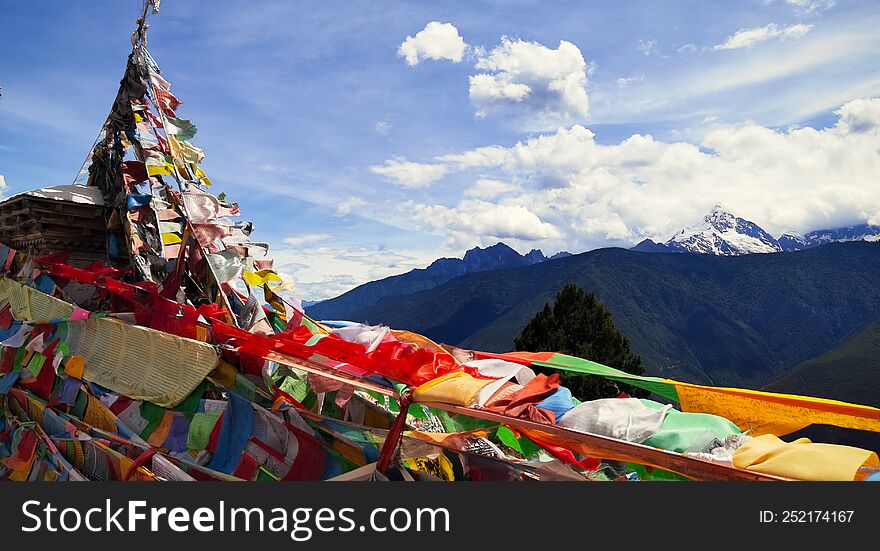 Looking at the Meili Snow Mountain in the distance through the prayer flags fluttering in the wind. Yun Nan China.