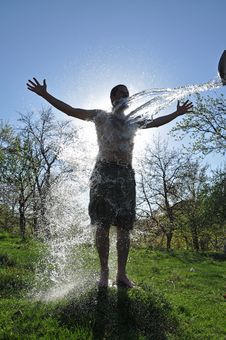 Male Enjoys The Water Splash In The Outdoors Stock Image