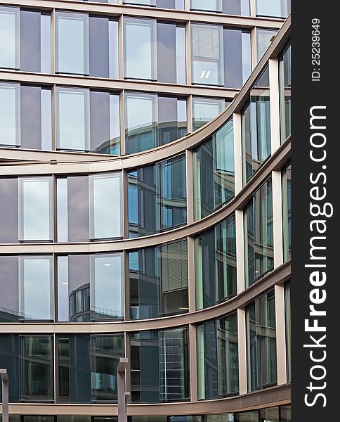 You see a modern building facade with building reflections in the city of Hamburg. You see a modern building facade with building reflections in the city of Hamburg.