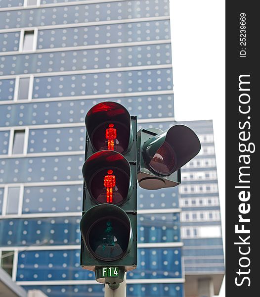 You see a traffic light in Hamburg with the red stop signal for people.