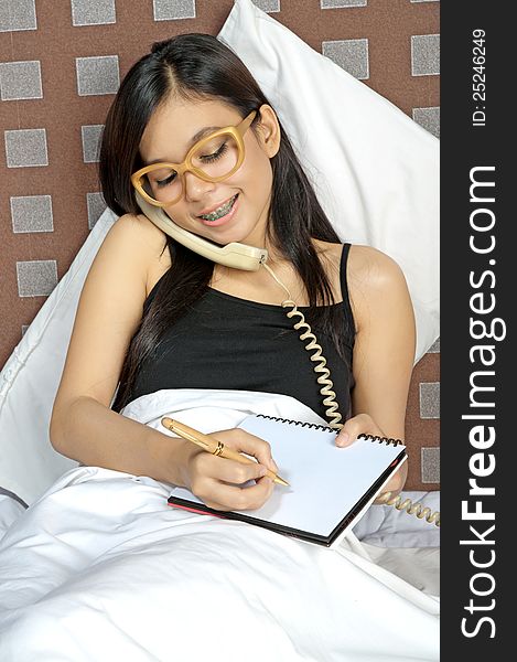 Asian woman call and write while in bed. Asian woman call and write while in bed