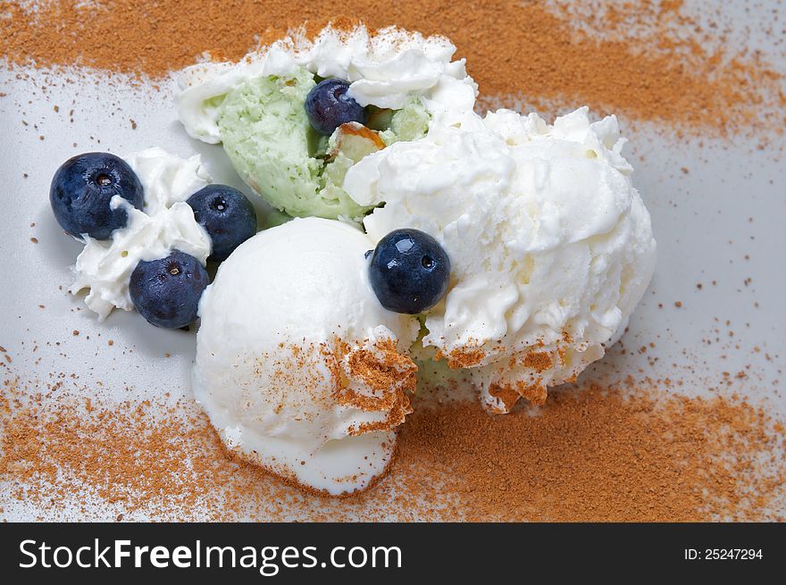 Arrangement of Ice Cream witn blueberry and cinnamon closeup on gray plate