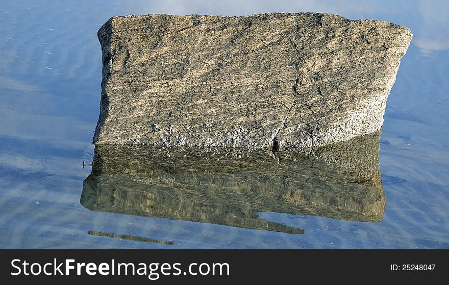 Rural stone with seashells reflected in ocean. Rural stone with seashells reflected in ocean