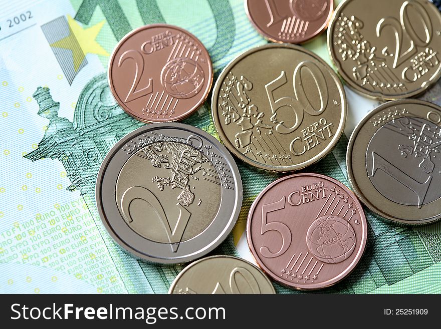 Closeup of European Union coins lying on one hundred euro bank note. Closeup of European Union coins lying on one hundred euro bank note