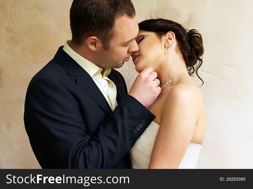 Groom kisses bride in empty room