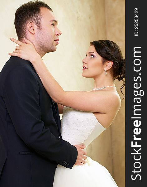 Bride and groom hugging in stylish empty room. Bride and groom hugging in stylish empty room