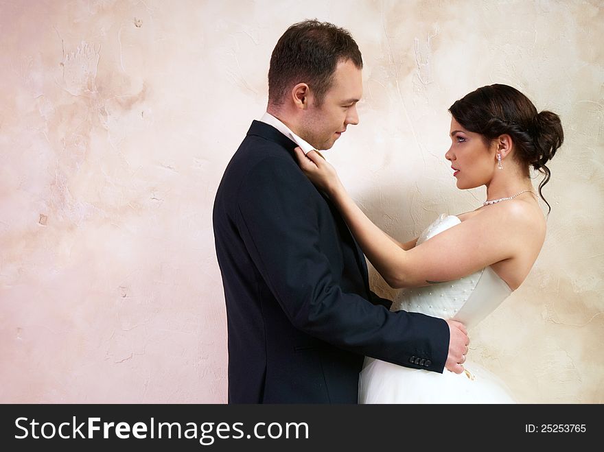 Bride and groom hugging in stylish empty room. Bride and groom hugging in stylish empty room