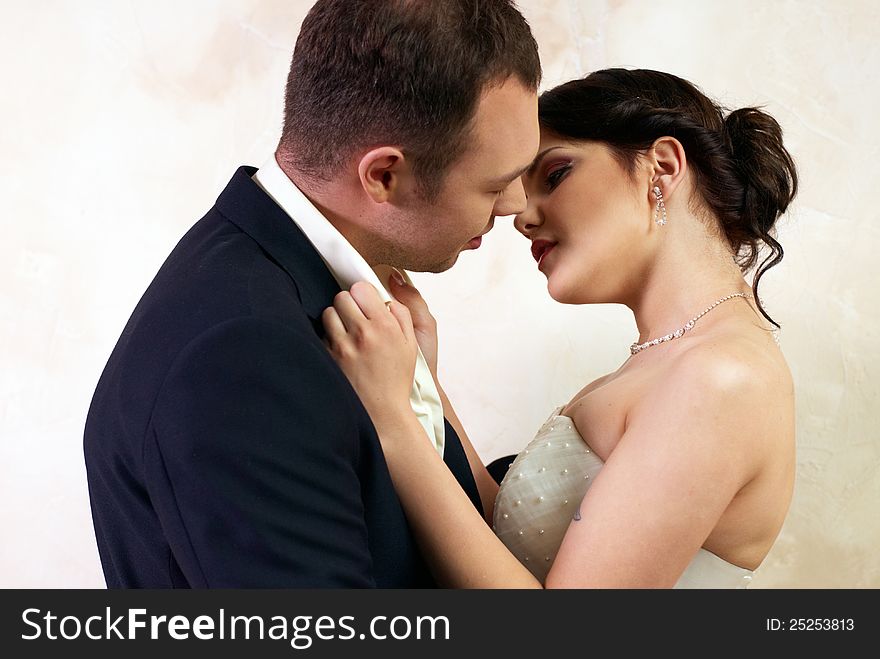 Groom kisses bride in stylish empty room. Groom kisses bride in stylish empty room