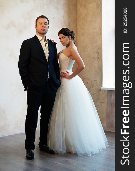 Bride And Groom Standing In Empty Room