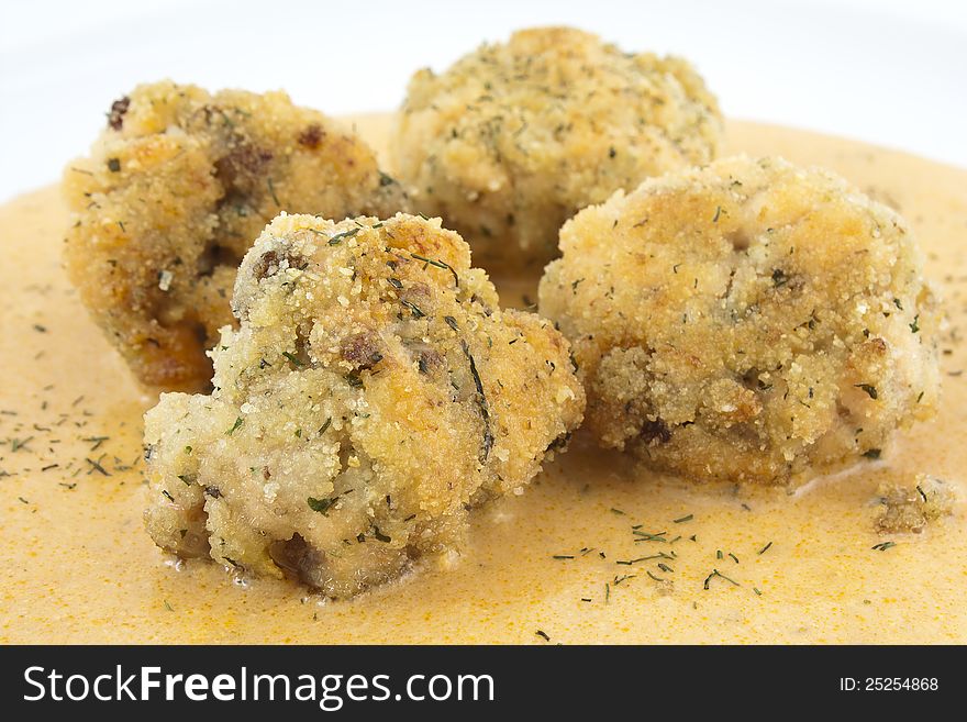 Close up of meatballs of salmon with sauce and decorated with dill