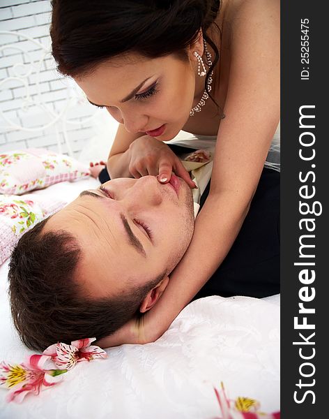 Bride And Groom Fooling In Bedroom With Orchids