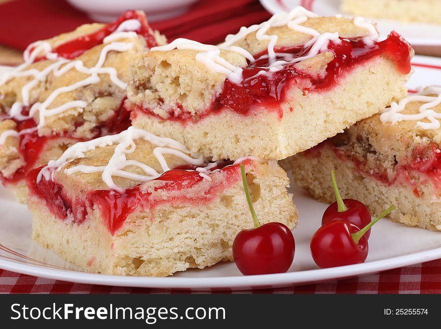 Closeup of cherry bars with cherries on a plate