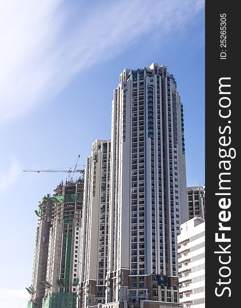 Buildings under construction and cranes under a blue sky