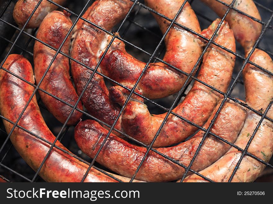 Closeup of sausages cooking on the grill. Good background. Closeup of sausages cooking on the grill. Good background