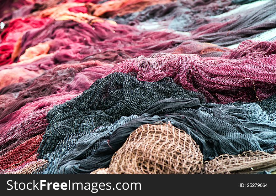 Red fishing nets drying on the port