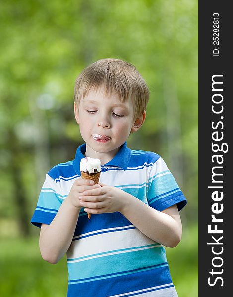 Happy child eating a tasty ice cream outdoor