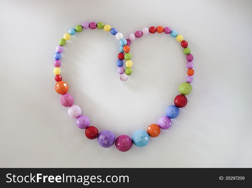 A colorful heart necklace on white background