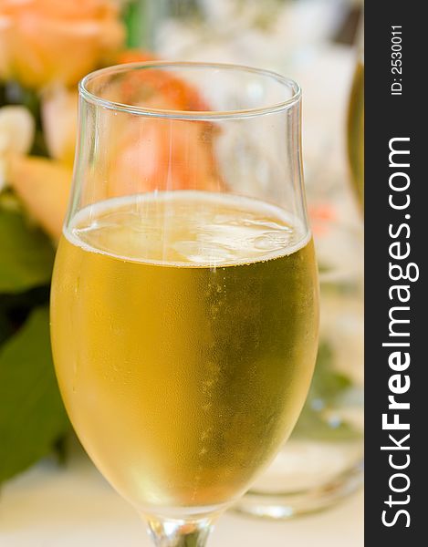 A Glass of Champagne with flowers in the background