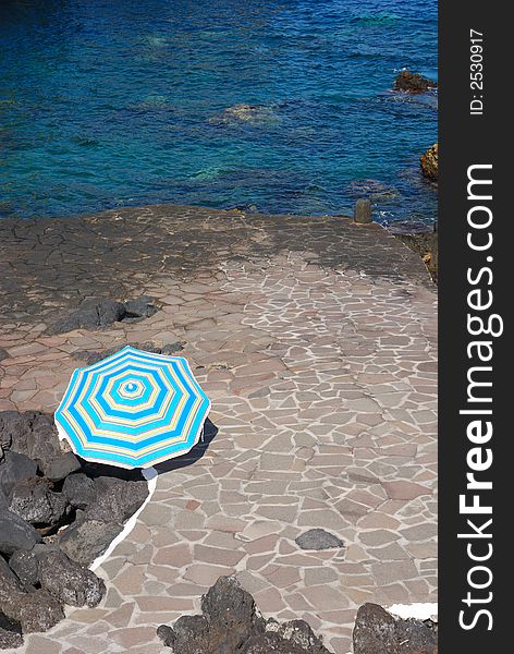 Parasol on a stony beach at tenerife