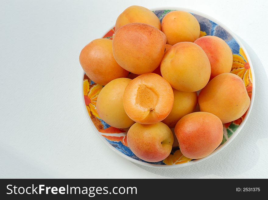Apricot fruits in plate on white. Apricot fruits in plate on white