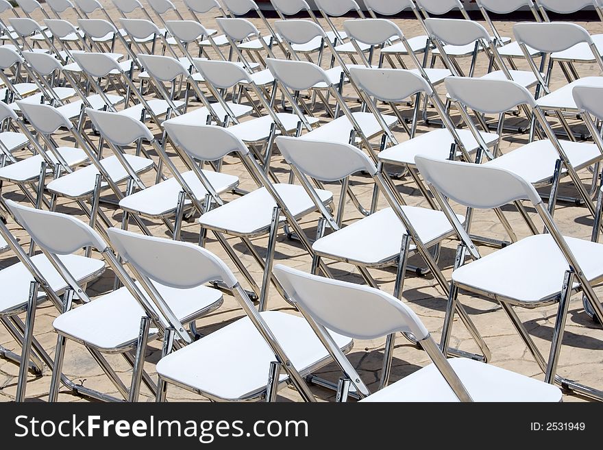 An array of white chairs waiting for the audience of an open-air event