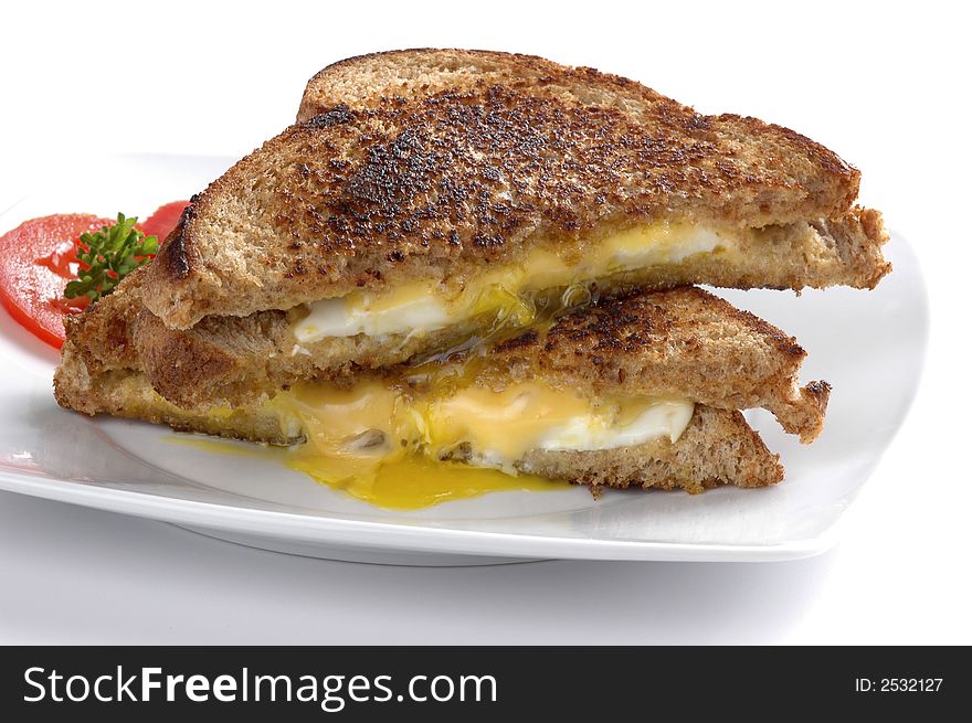 Messy fried egg sandwich with cheese on a white background.